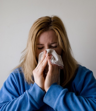 Woman blowing nose